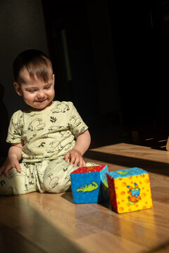Toddler playing with colorful soft blocks on sunlit floor Copy Space