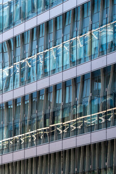 Abstract pattern geometry on modern glass building facade architecture using windows as a sleek background for corporate business branding and design