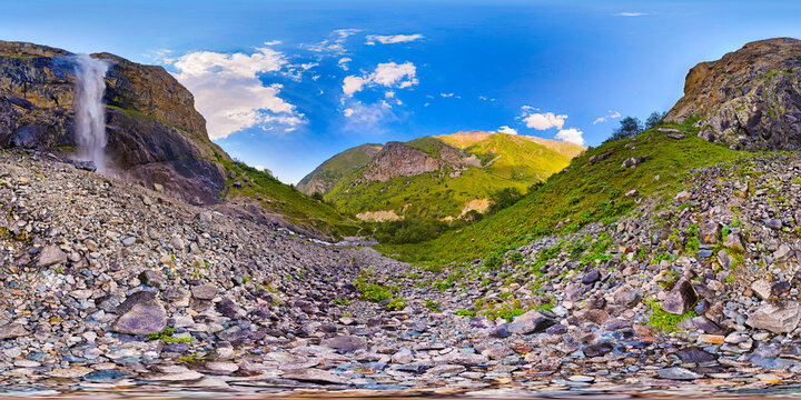 Majestic waterfall cascading down rocky cliff in mountain gorge, equirectangular 360 panorama.