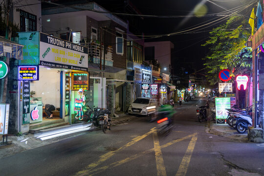 DA NANG, VIETNAM &ndash; 14 November 2025: A person sleeps outside a mobile phone repair shop on Le Huu Trac street in the Son Tra district at night.