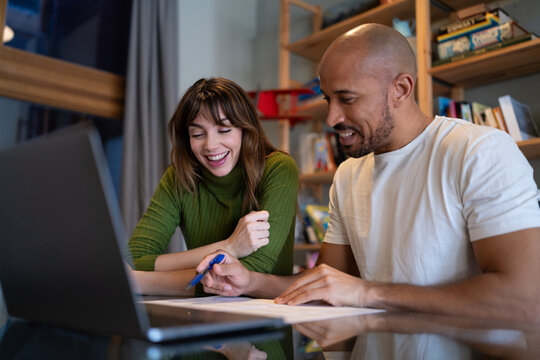 Couple discussing finance at home with laptop and paperwork