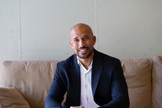 Confident businessman sitting on couch looking at camera