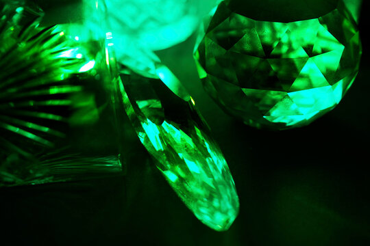 Glowing green crystal prism reflecting neon light in the dark