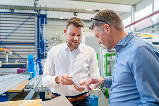 Colleagues discussing a prototype in a production hall