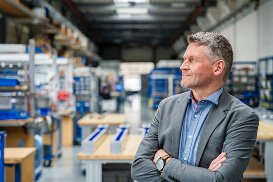 Satisfied manager standing in a production hall