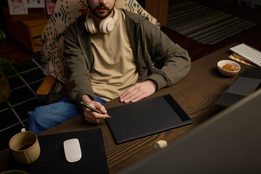 Digital artist drawing on a graphics tablet in a home office