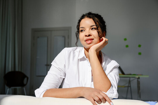 Woman smiling and relaxing in a sunny home office
