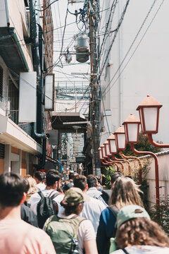 Rear view of crowd walking a narrow alley in Osaka