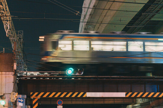 Motion blur of commuter train on railway bridge at night in Osaka