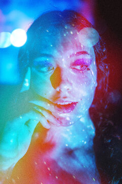Studio portrait of teenage girl illuminated by colorful led projector light