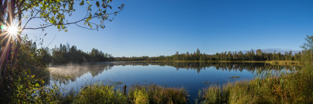 Panoramic view of a misty lake at sunrise in Estonia