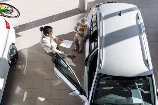 Car salesperson discussing with customer at showroom