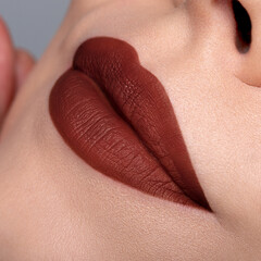 Fototapeta premium Warm brown matte lipstick on lips macro close up bold beauty look 