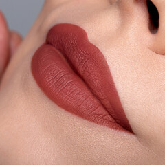 Fototapeta premium Rusty red matte lipstick on lips macro close up bold beauty look 