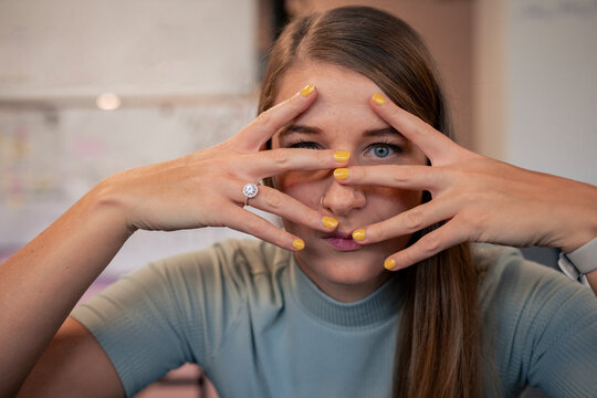 Young businesswoman covering face with hands in office