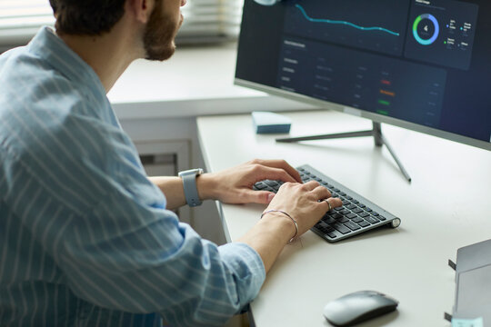 Analyst reviewing digital chart on computer in corporate office