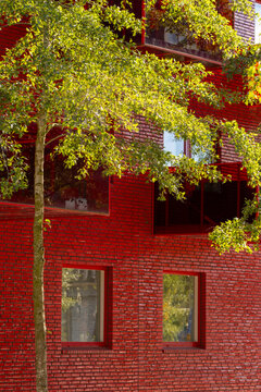 Sustainable urban scandinavia residential architecture uses modern red brick and windows with greenery to express daylight exterior design and ecology