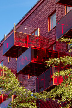 Sustainable urban scandinavia residential architecture with modern red brick facade and balconies capturing daylight exterior character and design