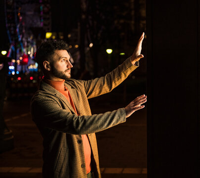 Man using touch screen kiosk at night