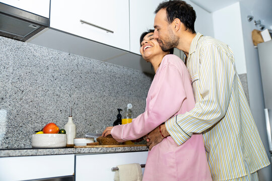 Loving couple preparing breakfast in kitchen at home