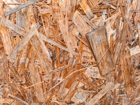 Pressed wood chip panel surface with brown strand texture for construction material background