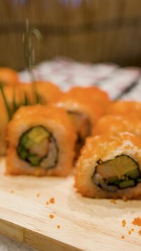 Metal Tongs Picking Up Fresh California Sushi Roll From Buffet Display