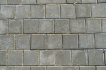 Obraz premium Texture of square brick-like gray concrete pavement with stack bond layout