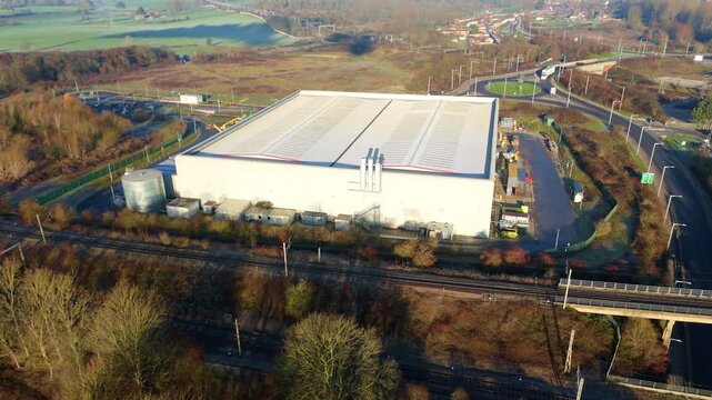 High-angle drone shot showing the connection between industrial warehousing and rail transport infrastructure in Warwickshire.