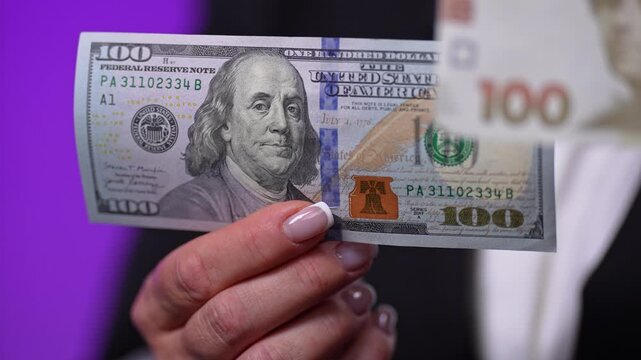 US $100 bill and a 100 Ukrainian hryvnia banknote сlose-up studio shot. The composition highlights a direct comparison between global and local currencies, symbolizing exchange rates.