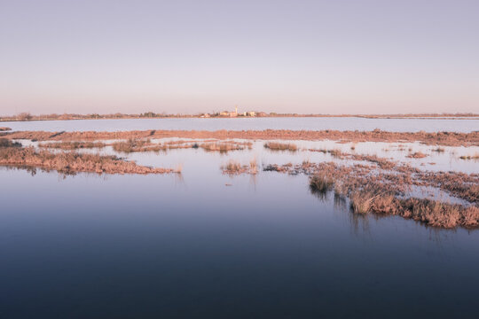 View of the small town of Lio Piccolo among the salt marshes in the Venetian lagoon at sunset