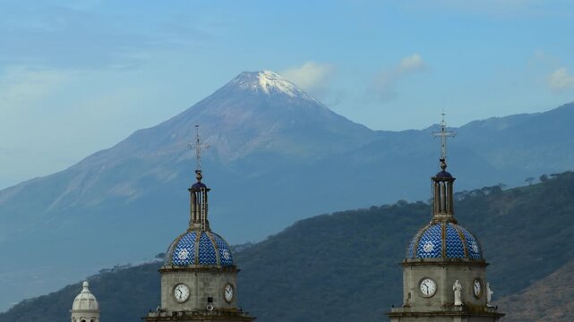 Templo de San Juan Bautista bell towers and volc&aacute;n de colima in Tuxpan, Jalisco, Mexico