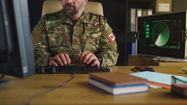 Canadian intelligence officer analyzing global threats while working on computer