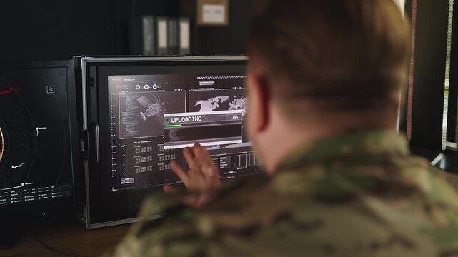 Male army officer uploading gathered data, sharing intelligence across agencies