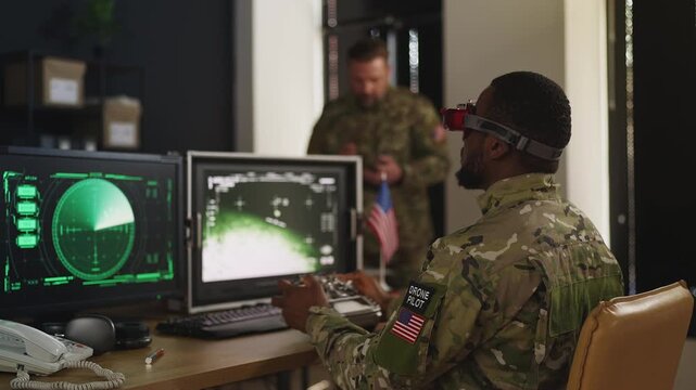 U.S. drone pilot in headset flying FPV simulator in military training hub room