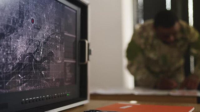 Intelligence officer planning ground offensive strategy using topographic maps