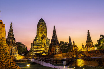 Fototapeta premium Beautiful ancient wat ayutthaya temple ruin glowing brightly under peaceful purple twilight sunset sky creating an inspiring tranquil historical landmark architecture for travel destination