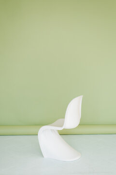 White Modern Plastic Chair on Green Background