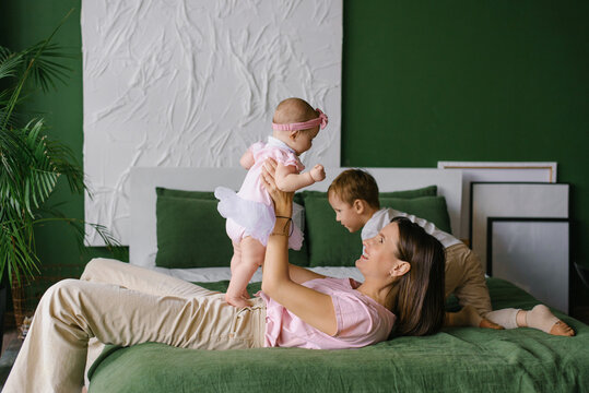 Mother Playing With Children On Bed