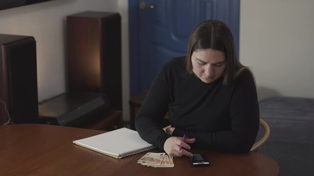 Two women review a phone message and react to bad financial news, useful for debt, budget stress, and personal finance crisis concepts.