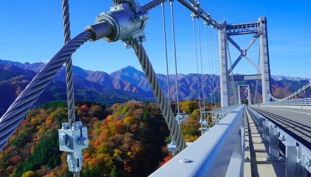 Modern Suspension Bridge With Steel Cables Over Colorful Mountain Valley Landscape
