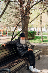 Fototapeta premium homeless person. Man sitting on park bench in city during daytime