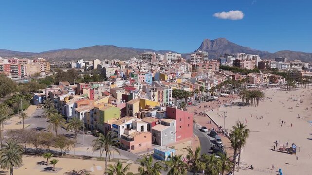 Ascending lateral drone shot with palm trees revealing Villajoyosa city