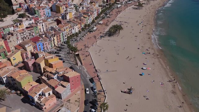 Ascending lateral drone shot revealing Villajoyosa colorful coastal city