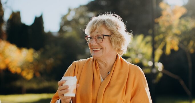 Happy senior woman holding coffee cup outdoors