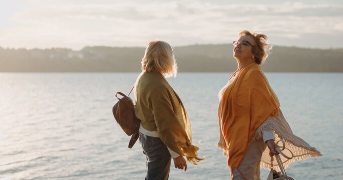 Senior friends enjoying golden hour by the water