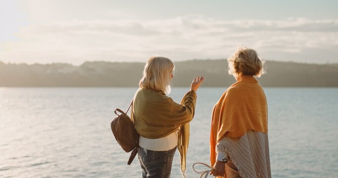 Senior friends enjoying conversation by tranquil lake