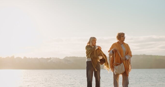 Senior friends enjoying sunset by the water