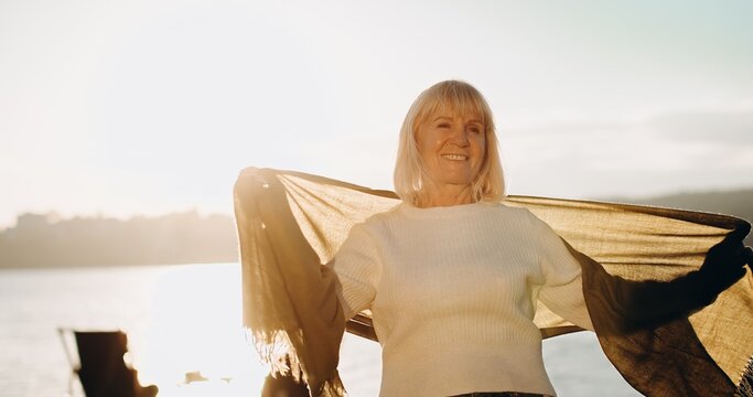 Senior woman smiling embracing freedom outdoors