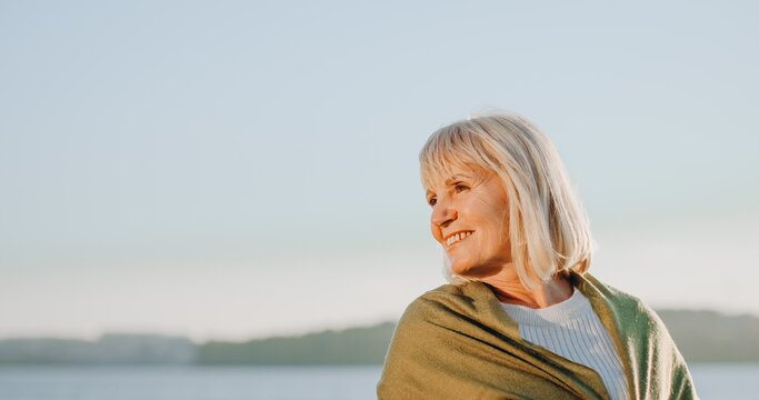 Senior woman smiling enjoying sunset outdoors portrait