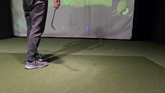 Golf practice session indoors using simulator with focus on swing and accuracy at a local sports center